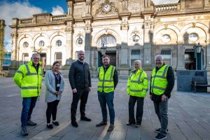 Morgan Sindall team in hi-vis jackets outside Accrington Market Hall with Hyndburn Borough Council's Markets Manager