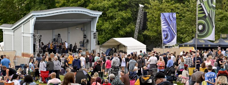 Oak Fest main stage, spectators in foreground, trees in background.