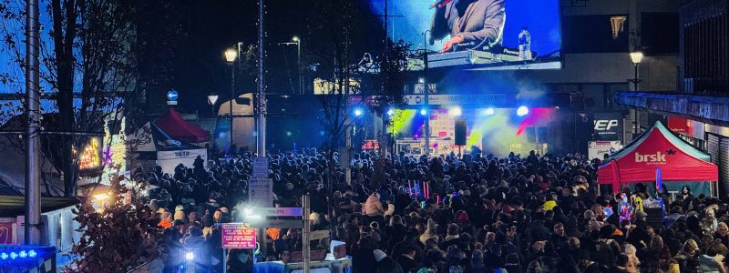 Crowds at Accrington Christmas Light Switch on with giant screen in background