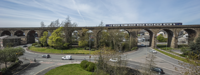 Accrington viaduct with train passing and blue skies
