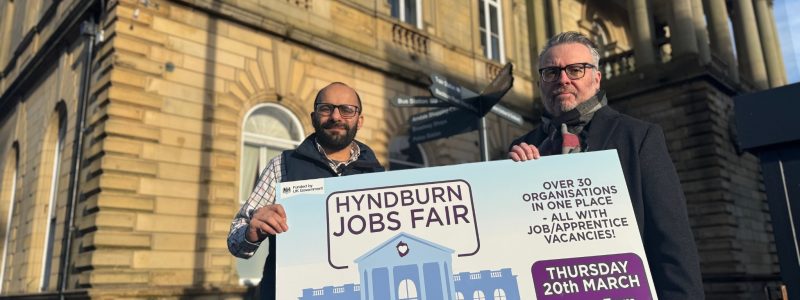 Two Councillors holding jobs fair sign, Town Hall in background