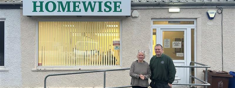 two people stood outside Homewise base. Disability access ramp in background