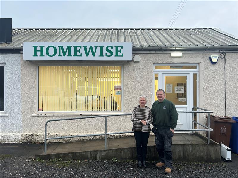 two people stood outside Homewise base. Disability access ramp in background