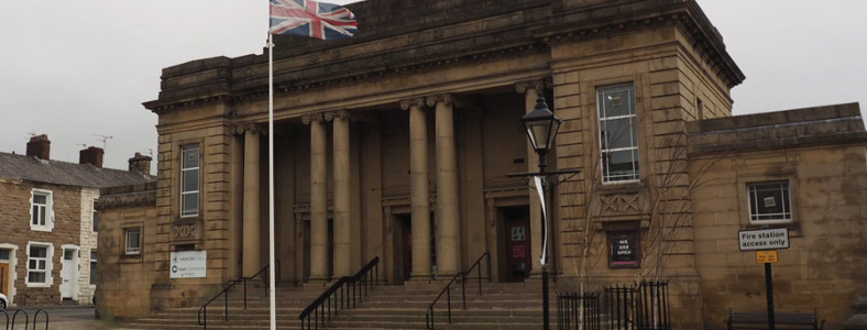 Large stone building. steps to the front and stone pillars. Union Flag flying infant of the building