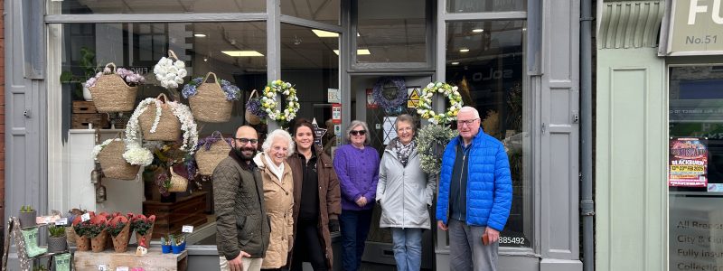 Six people outside shop with Gareths Florist sign