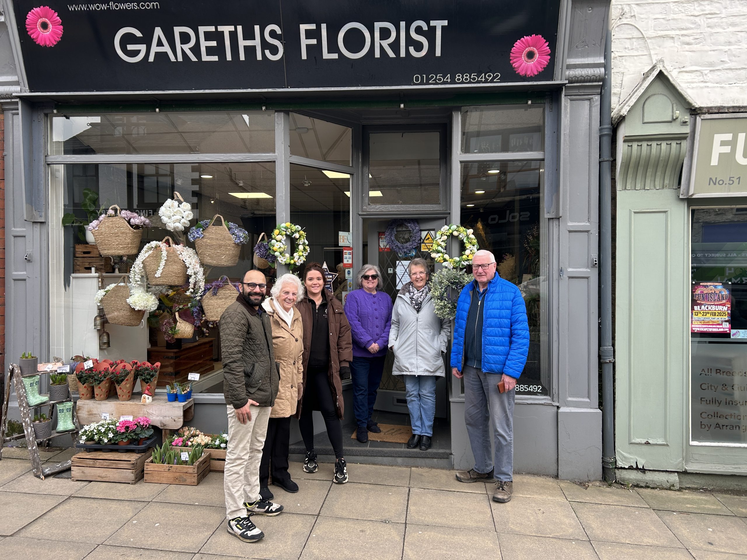 Six people outside shop with Gareths Florist sign