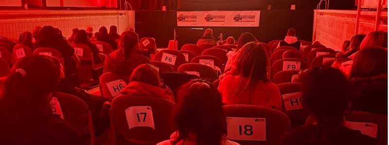 People watching movie in empty pool tank with red lighting