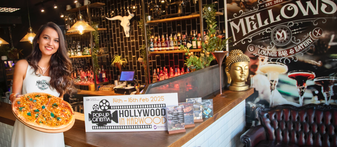 Woman holding pizza in restaurant