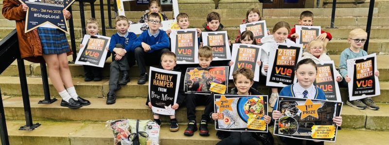 Children sat on stone steps holding prizes.