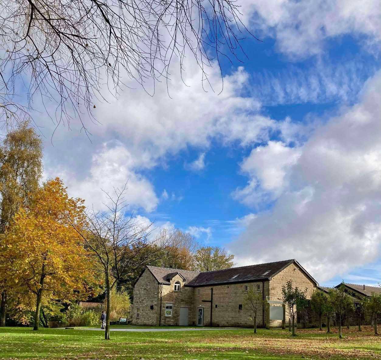 Coach house, trees and grass in foreground