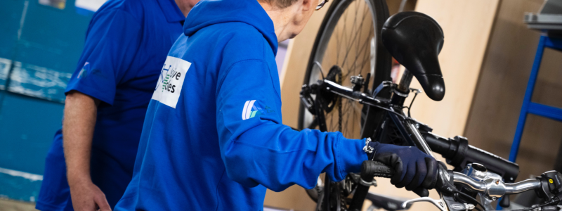 A person in blue jacket holding a bicycle