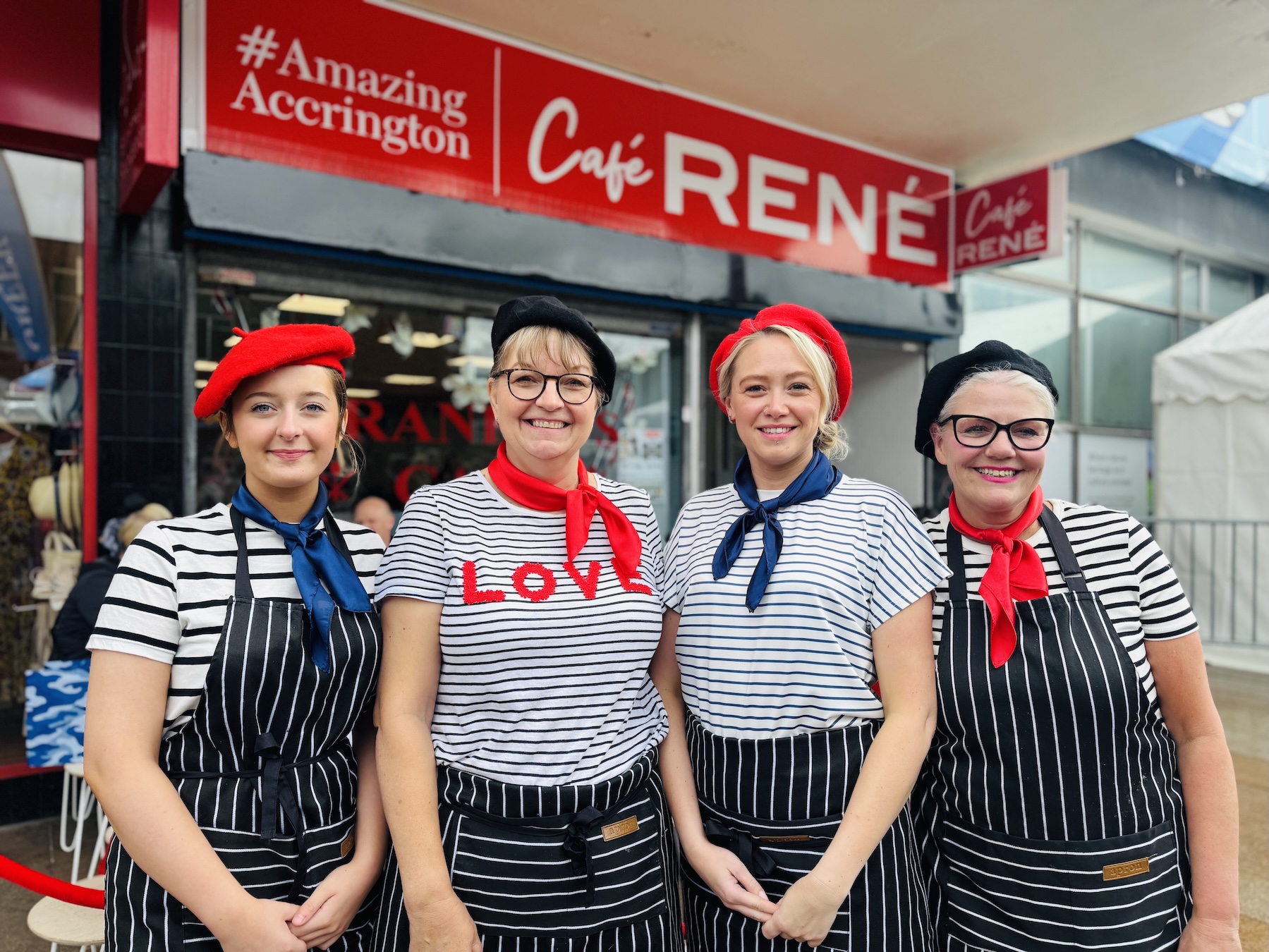 A group of women wearing striped aprons and berets
