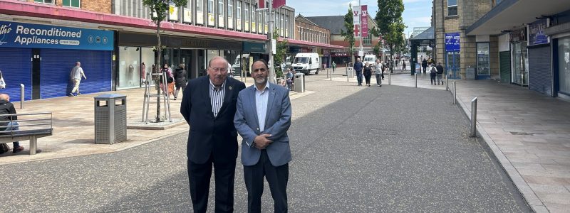 Two people standing on a high street