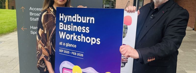 Two people holding a poster