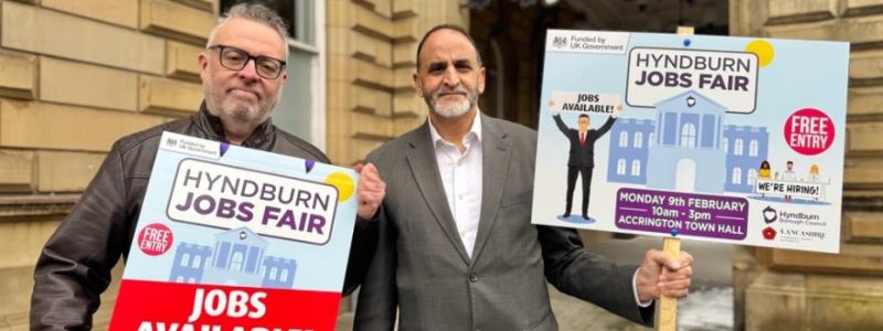 Two people holding jobs fair signs