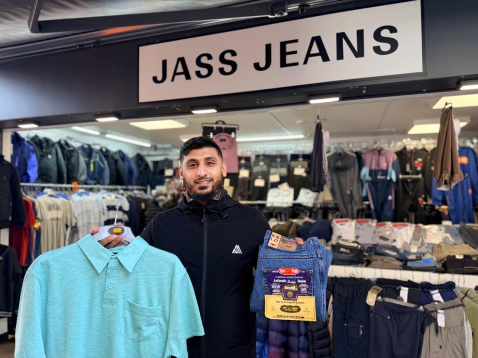 Person holding a pair of jeans and a polo shirt