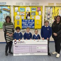 school children holding a giant cheque