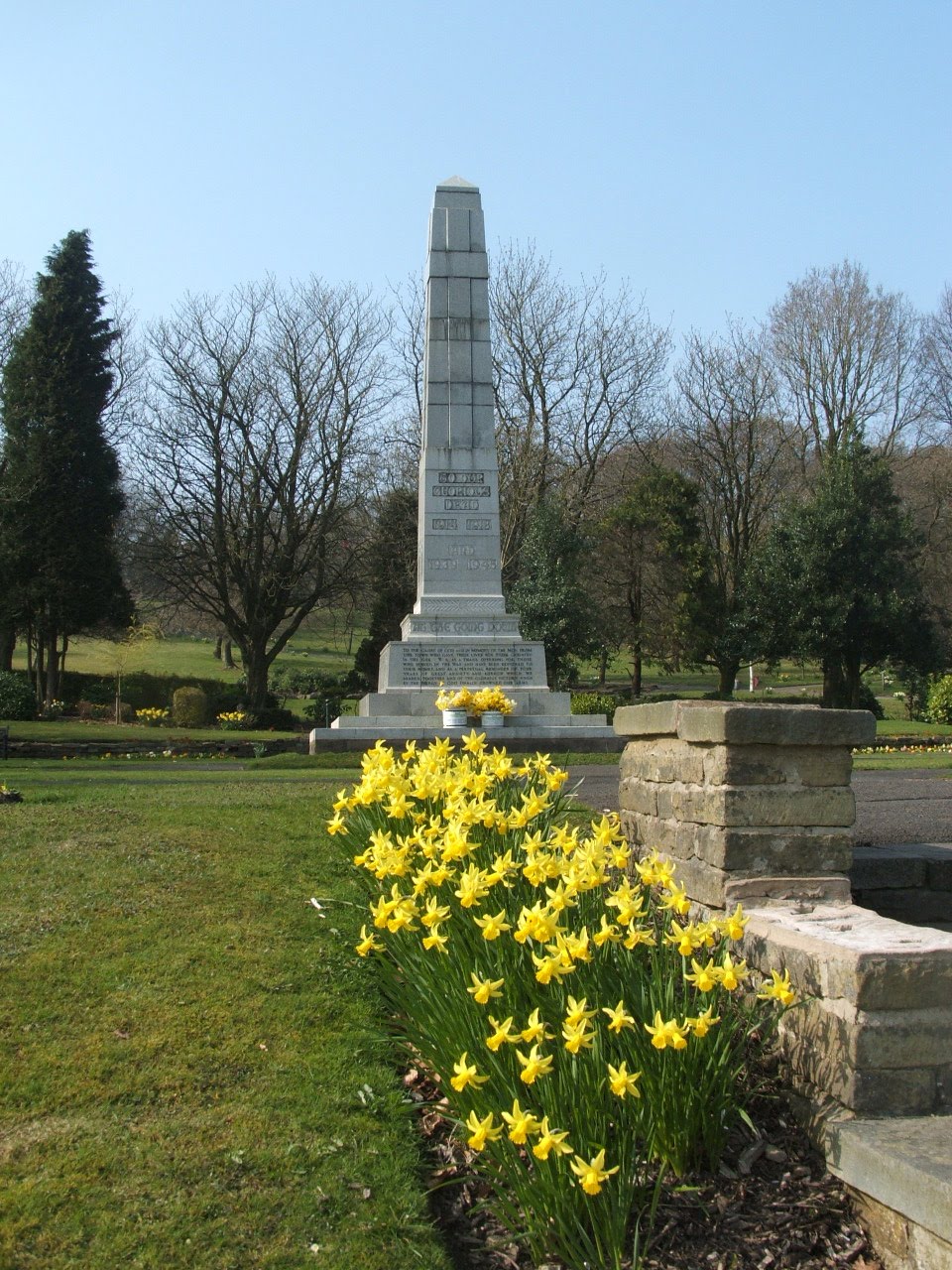 A war memorial with yellow flowers in the foreground