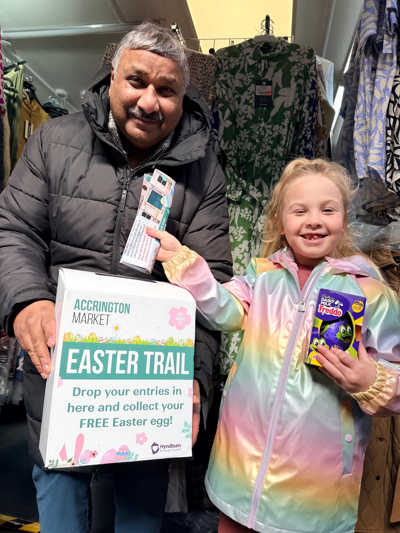 Two people holding easter themened posters and eggs
