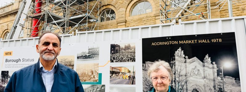 Two people in front of display hoardings