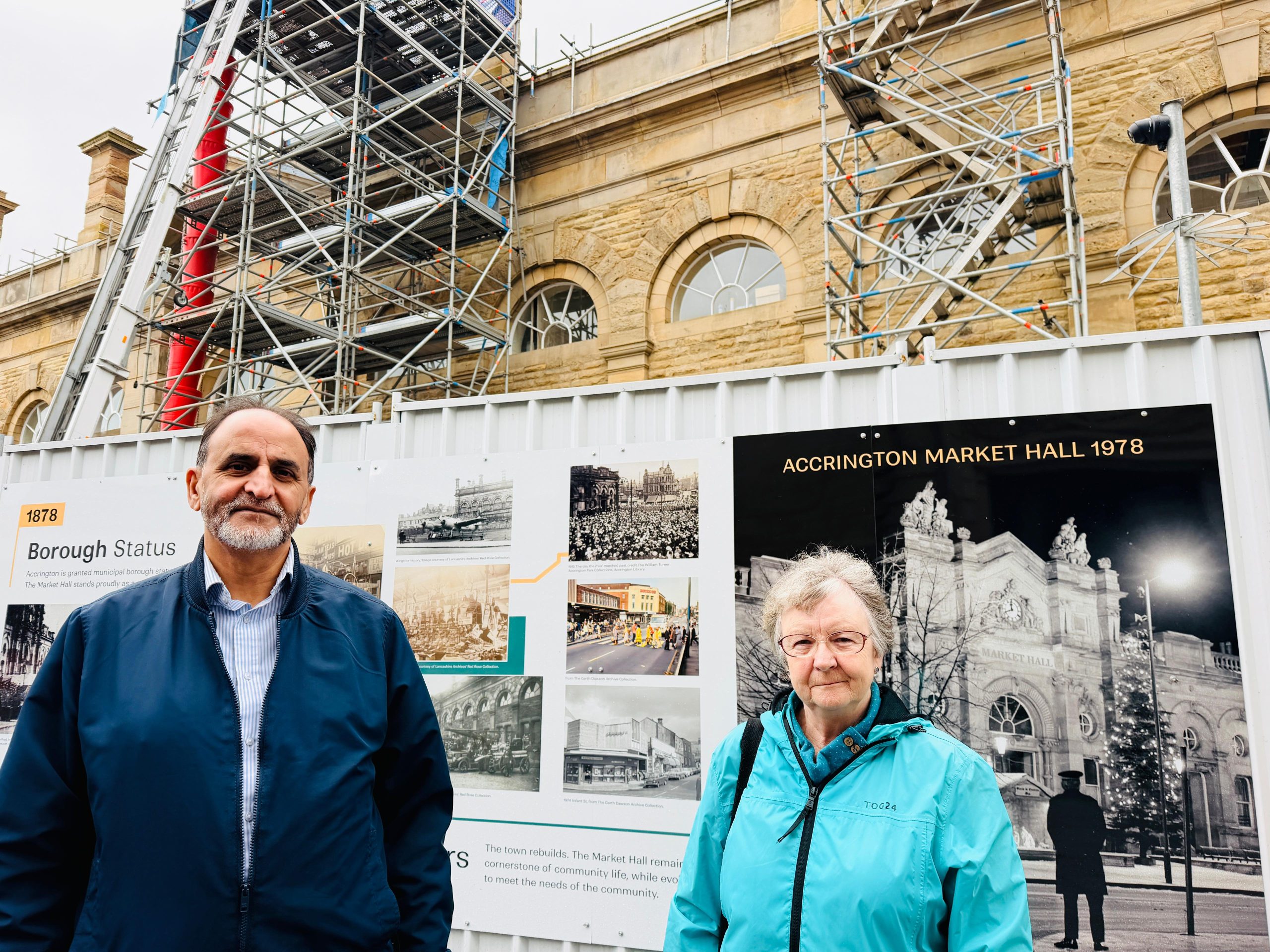 Two people in front of display hoardings