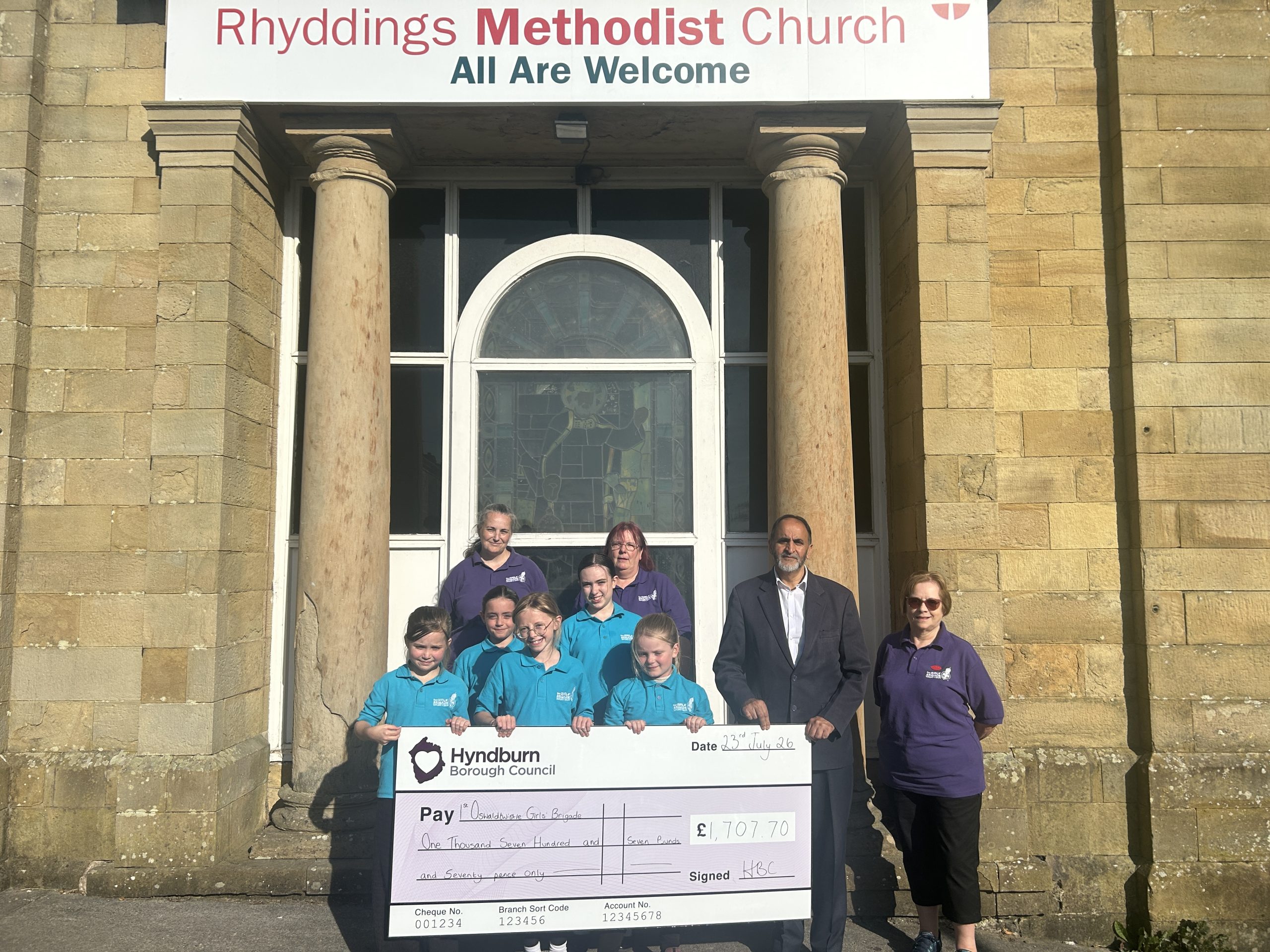 Group of people holding giant cheque