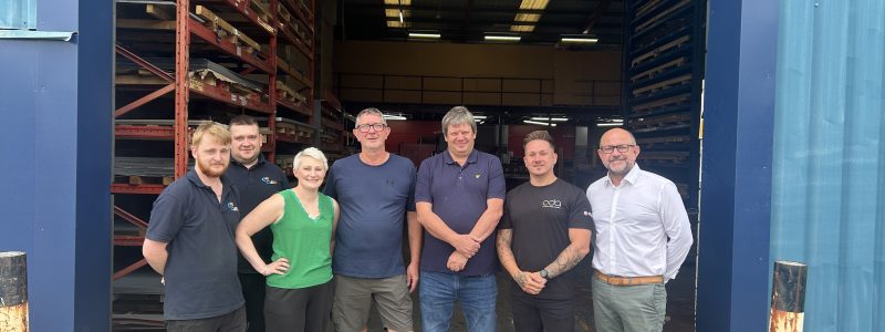 A group of people stood in front of a warehouse